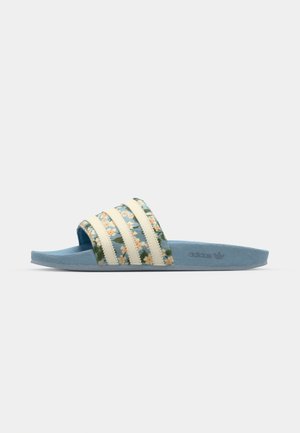 Adidas sandala s trakom s uzorkom koja ima žute cvjetove, svijetloploti đon i tri bijele akcentne pruge na trakama.