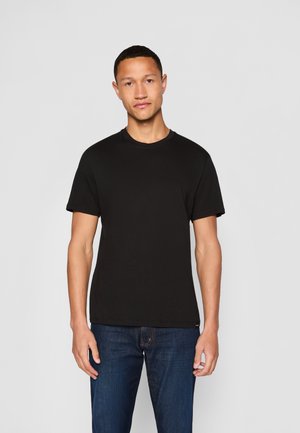 Black cotton t-shirt with a crew neckline and short sleeves, paired with dark blue denim jeans. Simple, solid color without patterns.