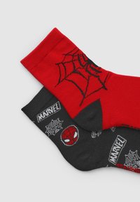 Calzettoni rossi e neri con un design a ragnatela di Spider-Man, con accenti neri e loghi Marvel sulla calza scura. Tessuto morbido e lavorato a maglia.
