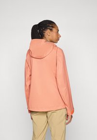 Jachetă rezistentă la apă, de culoare coral, cu glugă, textură netedă, mâneci lungi, manșete ajustabile și un design curat, minimalist.