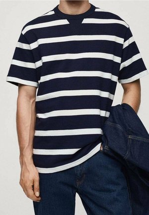 Marineblå og hvide stribede T-shirt med korte ærmer, rund hals og afslappet pasform, kombineret med mørke denimjeans. Enkel, afslappet stil.