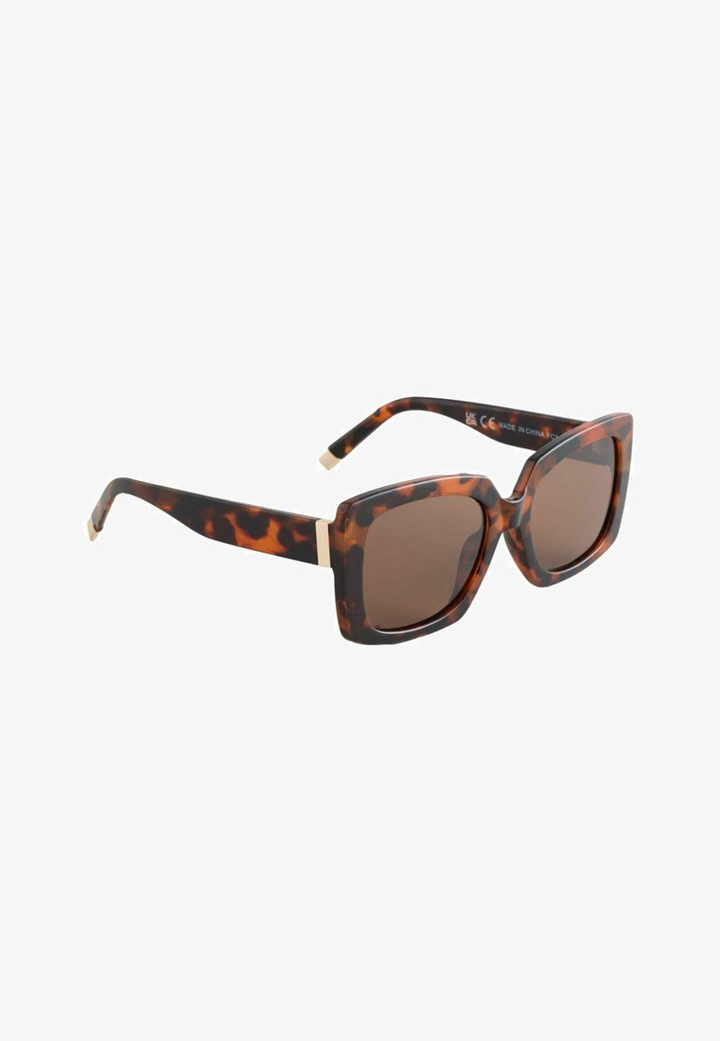 Lunettes de soleil carrées écaille de tortue marron avec des branches larges et des verres teintés foncés, inclinées vers la droite sur un fond blanc.