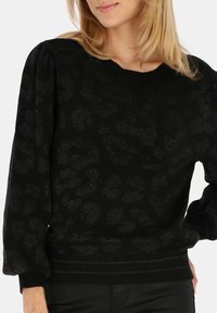 Czarny sweter z pulowerem z teksturowanym wzorem w panterę, lekko po�łyskujący, z prążkowanym dołem. Posiada bufiaste rękawy i okrągły dekolt.