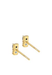 Goldfarbene Steckerohrringe in Form einer Ampel, mit drei farbigen Steinen – zwei schwarze und einem blauen – auf einem schlanken Steg.