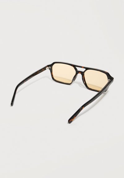 Tortoiseshell rectangular sunglasses with amber-tinted lenses, laid flat on a white surface.