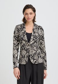 Blazer noir et crème à motif, coupe ajustée, col à revers cranté et manches longues. Présente des motifs floraux et géométriques élaborés.