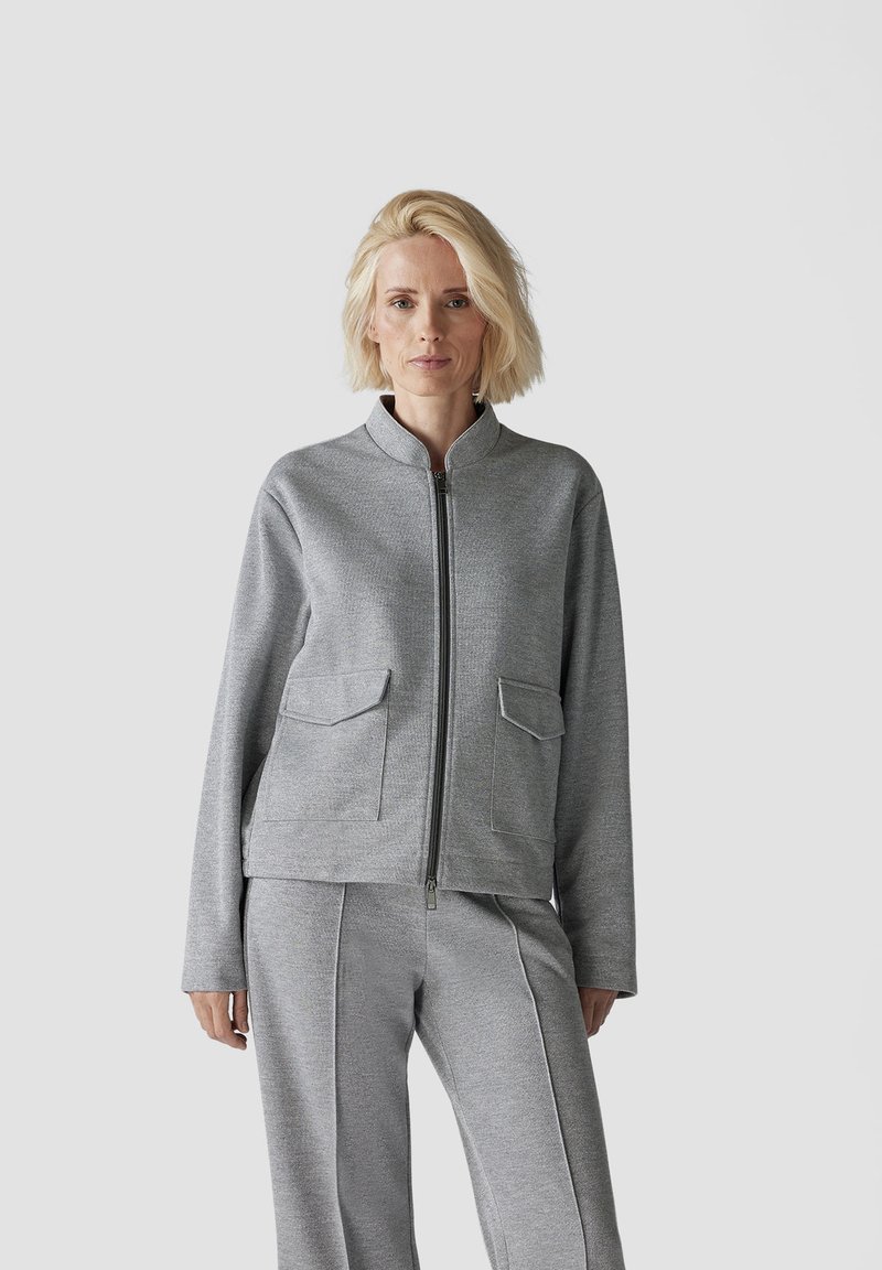 Gray zip-up jacket with two front pockets, textured fabric, high collar, and matching gray pants, creating a coordinated look.