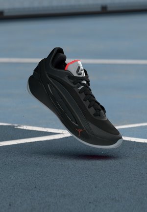 Sort atletiksko med mesh-overdel, grå accenter, røde detaljer på hælen og hvid gummisål med et logo på siden.