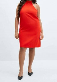 Rode halternekjurk met een aansluitende silhouet, zachte satijnen stof, knielang, gecombineerd met zwarte spitse hakken.