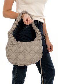 Quilted light gray handbag with a soft, padded texture, a gathered handle, and zipper closure, featuring a diamond pattern on the body.