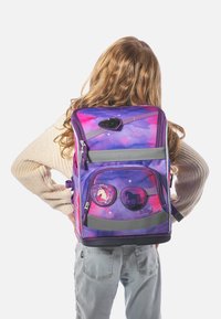 Zaino per bambini viola con motivo galattico e grafiche di unicorni. Presenta più scomparti, cerniere e un dettaglio a forma di cuore testurizzato.