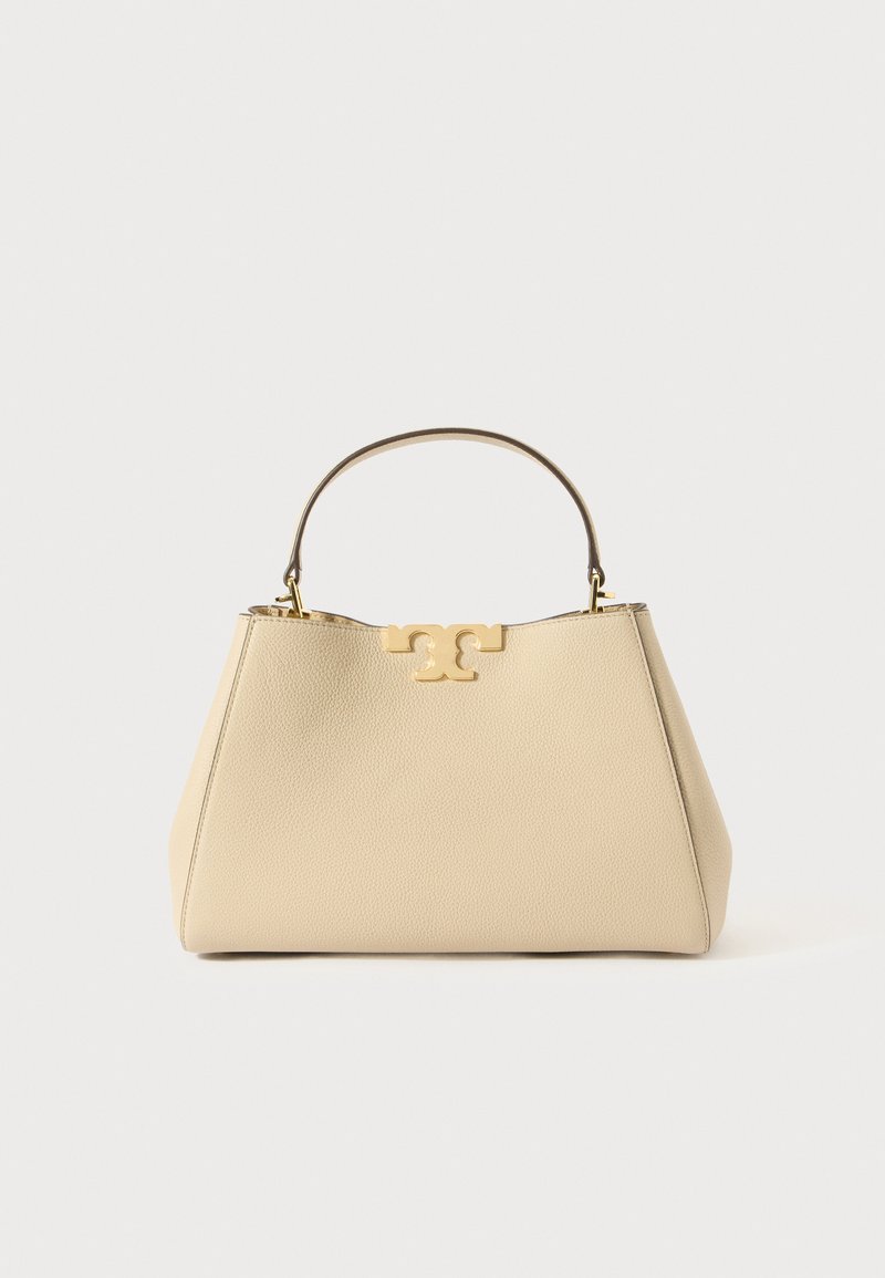 Beige Lederhandtasche mit strukturierter Form, ausgestattet mit einem goldfarbenen Logo-Akzent und einem kurzen oberen Griff. Glatte Oberfläche.