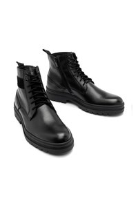 Czarne skórzane botki z teksturowanym wykończeniem, sznurowanym projektem, bocznym zamkiem błyskawicznym oraz grubą gumową podeszwą z wzorem bieżnika.