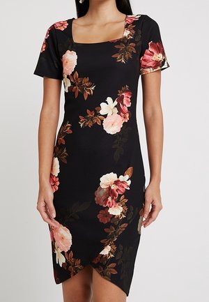 Musta, lyhythihainen, vartalonmyötäinen mekko, jossa on vaaleanpunainen, valkoinen ja ruskea kukkakuosi sekä neliömäinen kaula-aukko. Mekkoa käyttää seisova henkilö.