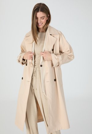Beige trench coat made of lightweight fabric, featuring a double-breasted front, two front pockets, and a wide collar. Smooth texture.