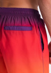 Pánské plavky mají gradientní design, který přechází z fialové do červené, s elastickým pasem a zadní kapsou.