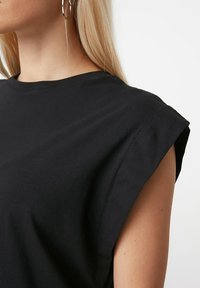 Czarny t-shirt z krótkim rękawem, o szerokim dekolcie i usztywnionych ramionach, wykonany z gładkiej mieszanki bawełny.