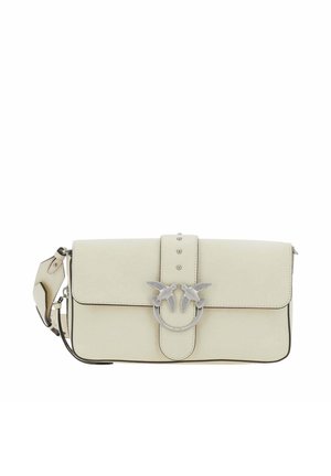 Sac à bandoulière en cuir crème avec deux oiseaux argentés se faisant face sur une fermeture circulaire et une sangle réglable.