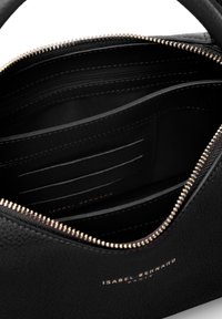 Black leather handbag interior featuring a zip closure, multiple card slots, and smooth texture. Gold-tone zipper and brand logo visible.