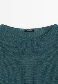 Pull tricoté bleu sarcelle avec un large col rond et une étiquette noire Massimo Dutti cousue à l'intérieur du col.