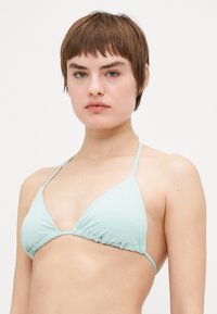 Menta zöld háromszög bikini felső vékony állítható pántokkal és ráncolt részletekkel az alján. Rugalmas fürdőruha anyagból készült.