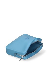 Una pochette con cerniera di un blu chiaro, con una superficie liscia e texturizzata, parzialmente aperta per rivelare un interno coordinato.