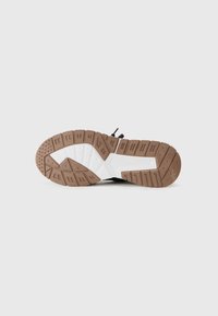 Brown rubber outsole with patterned tread, white midsole. Features textured surface and grooves for traction, with subtle design accents.
