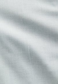 Helles graues Gewebe mit einer subtilen, strukturierten Webart; erscheint in unterschiedlichem Licht glatt und leicht reflektierend.