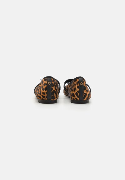Mokkasiner med leopardprint som har et mykt stoffoverdel, sorte detaljer, rund tå og flat såle. Inkluderer en liten dekorativ detalj på hælen.