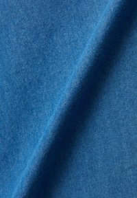 Tissu bleu avec une texture lisse et un motif légèrement chiné, montrant un tombé doux et une couleur uniforme tout au long.