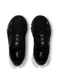 Black athletic shoes with mesh upper, contrasting white sole, round laces, and logo details on the sides and tongue.