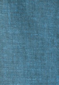Gros plan sur un tissu bleu étroitement tissé avec un motif de grille subtil et de légères variations de texture.