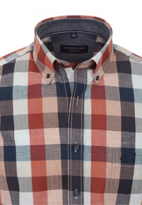 Kostkovaná košile v červených, modrých a béžových odstínech; volný střih s límečkem na knoflíky a ná prsní kapsou. Měkká tkanina s texturovaným vzorem.