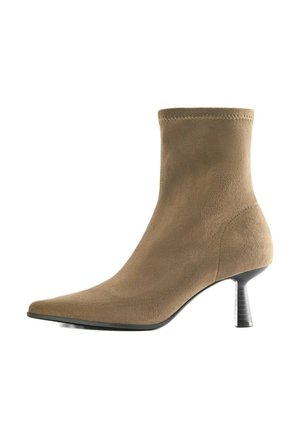 Bottine en daim beige avec bout pointu et talon moyen fin noir, texture lisse et bord cousu.