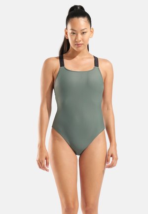 Olivgrüner Badeanzug mit breiten schwarzen Trägern. Verfügt über einen quadratischen Ausschnitt und eine glatte, matte Textur.