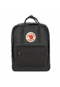 Mochila de tela gris con un bolsillo frontal negro con cremallera, dos asas superiores y un parche de logo rojo con un zorro. Diseño plano y estructurado.