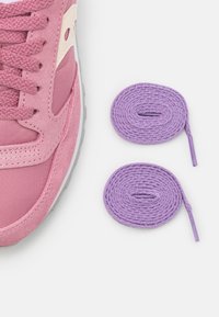 Rosa joggesko med teksturert stoff og glatte overflater, parret med to runde lavendel snørebånd.