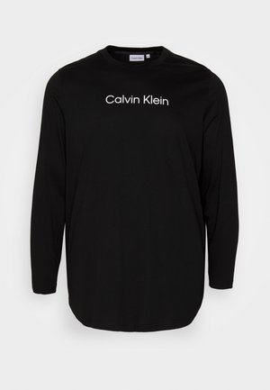Chemise noire à manches longues avec le logo "Calvin Klein" en blanc centré sur la poitrine, dotée d'un col rond et d'un ourlet arrondi.