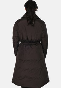 Dunjakke i mørk brun, med høy krage, elastisk midje og en midtlengde design med en glatt, quiltet tekstur.