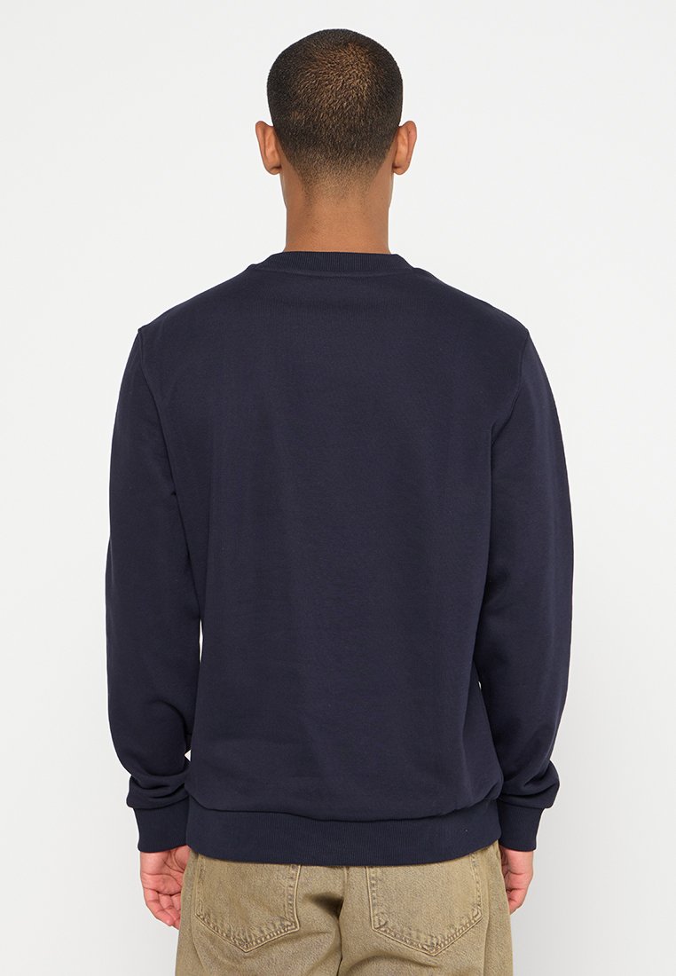 Felpa blu navy con collo rotondo e polsini a coste. Presenta un design semplice con una consistenza morbida, vista da dietro.