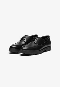 Chaussures en cuir noir avec une finition lisse, dotées d'un bout arrondi, d'un laçage à l'avant et d'une semelle en caoutchouc avec un motif cranté.