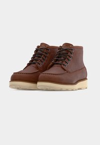 Καφέ δερμάτινες μπότες με υφή, στρογγυλερή μύτη και ραμμένες λεπτομέρειες. Γκρι κορδόνια και ελαφρύ καουτσούκ πέλμα ολοκληρώνουν το σχέδιο.