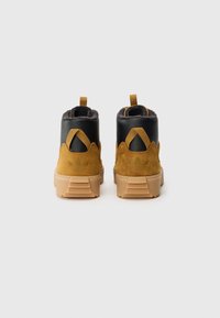 Καφέ σουέτ και μαύρα δερμάτινα μποτάκια μέχρι τον αστράγαλο με υφή στη γκρι επένδυση, επίπεδες λάστιχες σόλες και θηλιές για εύκολη φόρα. Λογό�τυπο εμφανές στη φτέρνα.