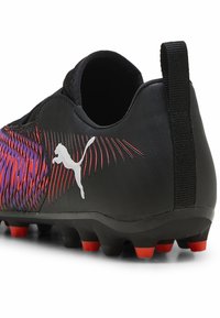 Scarpe da calcio nere con superficie testurizzata, accenti vivaci in viola e rosso, logo Puma prominente e tacchetti nella suola.
