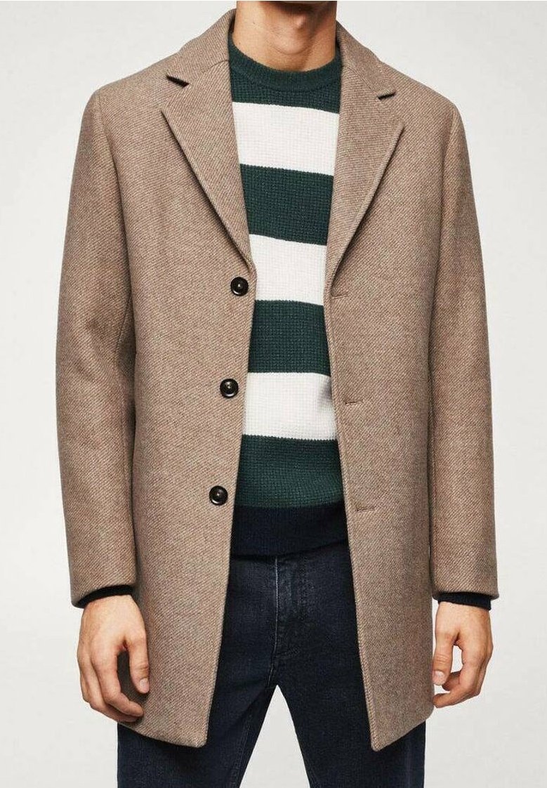 Beżowy płaszcz w jodełkę z klapami z wycięciem, czarnymi guzikami i dopasowanym fasonem, noszony na zielono-białym paskowanym swetrze.