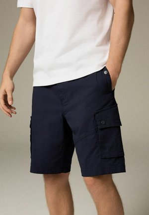 Marine Cargo-Shorts aus strukturiertem Stoff, mit seitlichen Taschen mit Klappen, genähten Akzenten und einem Knopfverschluss am Bund.