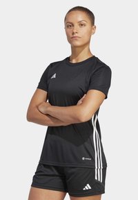 Černé sportovní tričko vyrobené z umělého materiálu, s krátkými rukávy, kulatým výstřihem a bílými pruhovanými detaily po stranách.