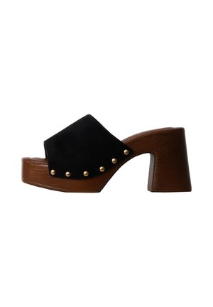 Sandale mule à plateforme en bois marron avec talon épais, dessus en cuir noir et clous dorés décoratifs le long du bord.