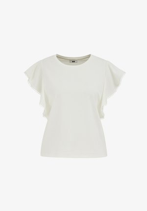 Biela krátka blúzka s krátkym rukávom s volánikmi lemovanými malými kruhovými ozdobami okolo okrajov a okrúhlym výstrihom.