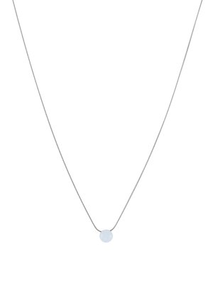 Collier en chaîne argentée avec un petit pendentif rond, opaque et blanc, centré sur un fond blanc.